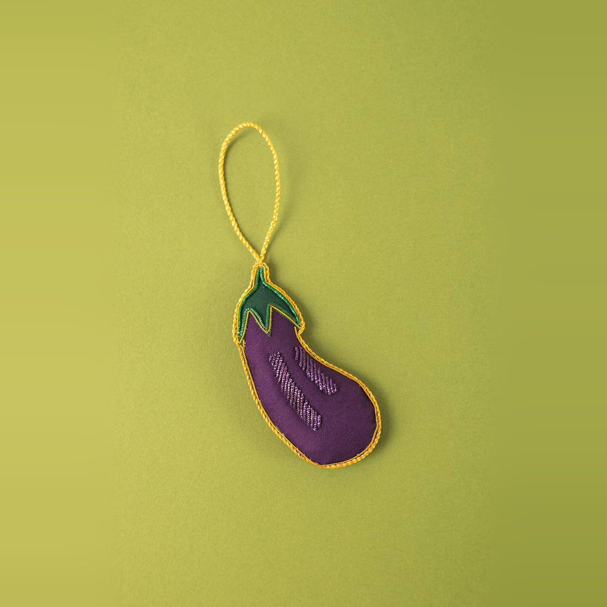 Aubergine embroidered Christmas decoration in purple with green stalk and gold outline on a green background