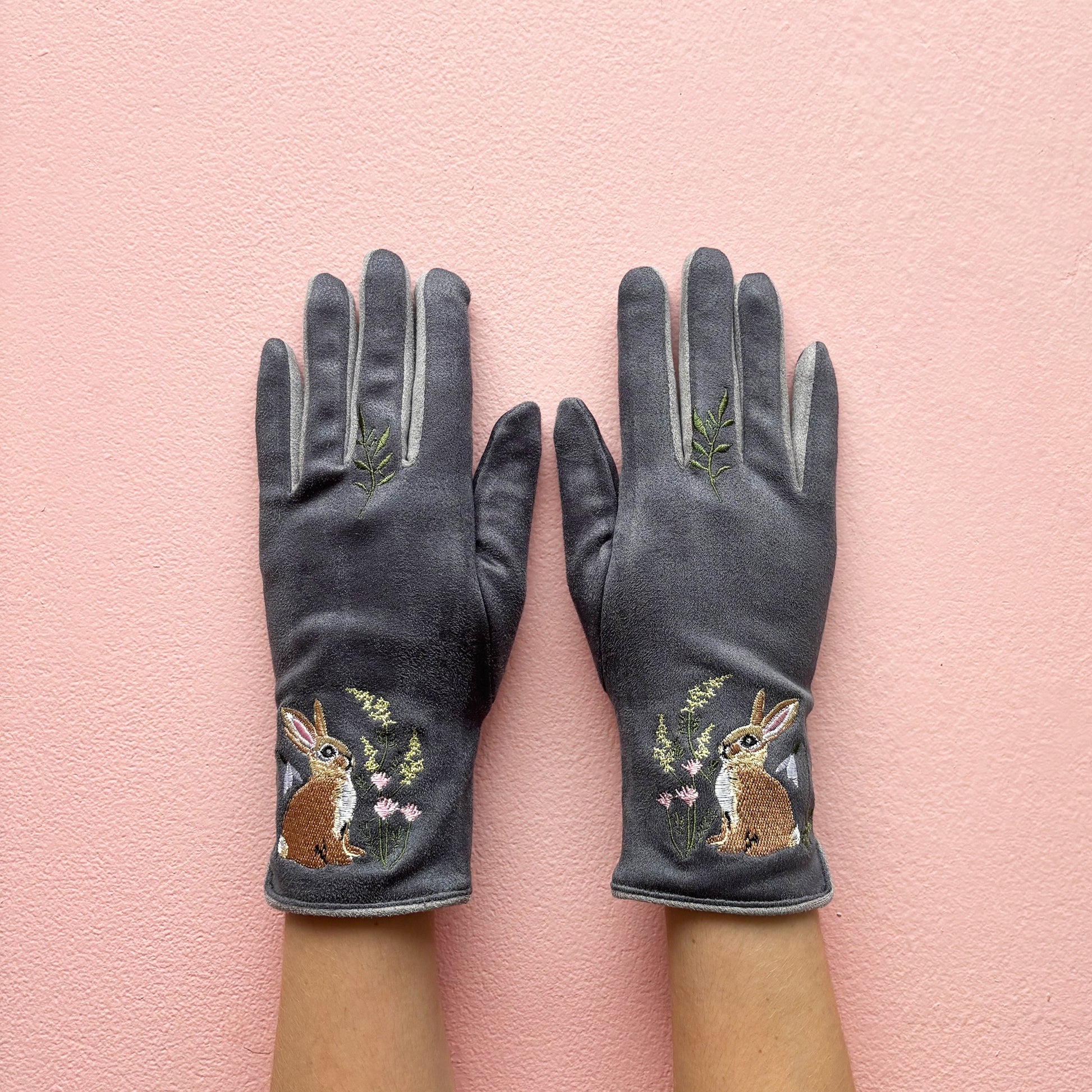 Grey embroidered rabbit gloves pair showing front design on pink background