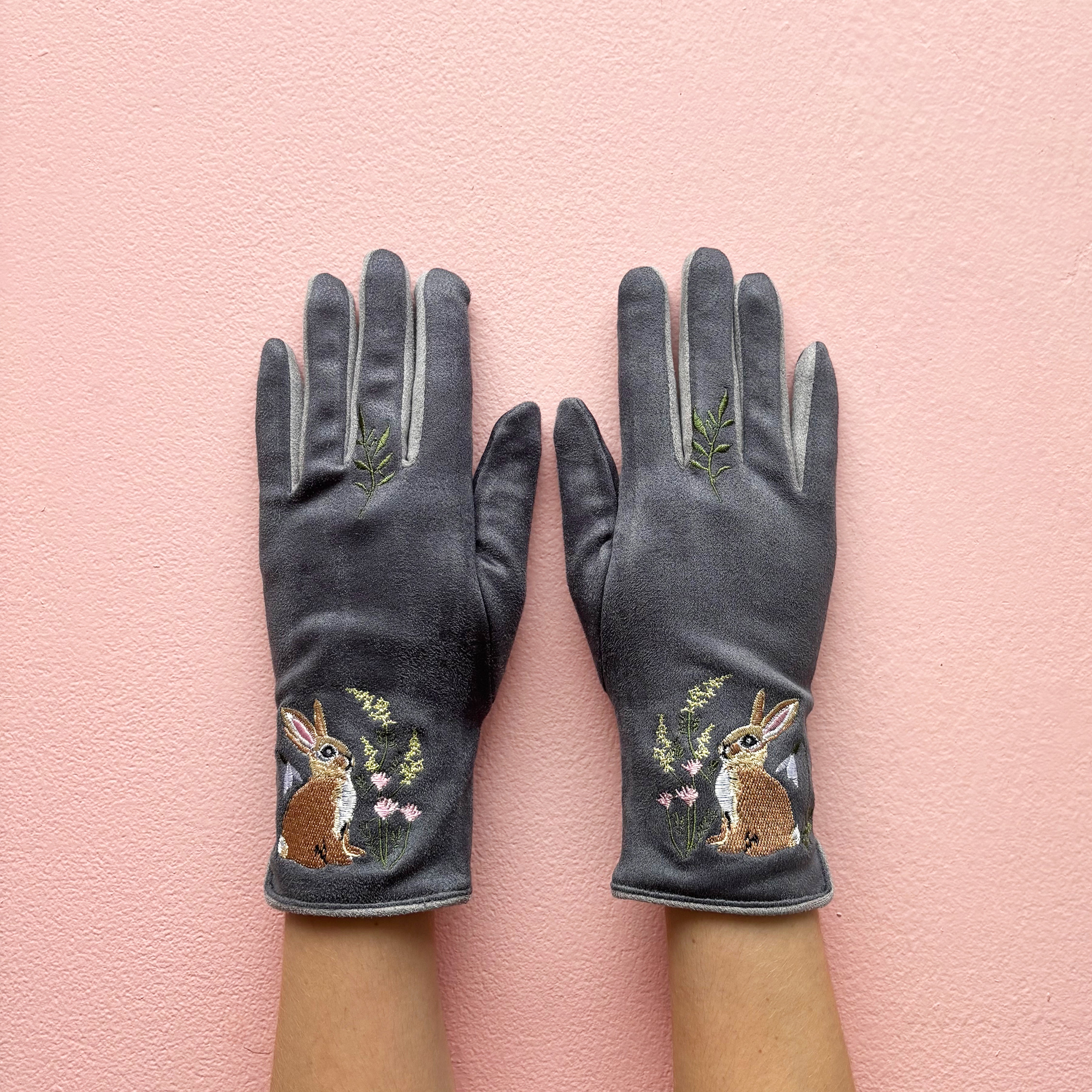 Grey embroidered rabbit gloves pair showing front design on pink background