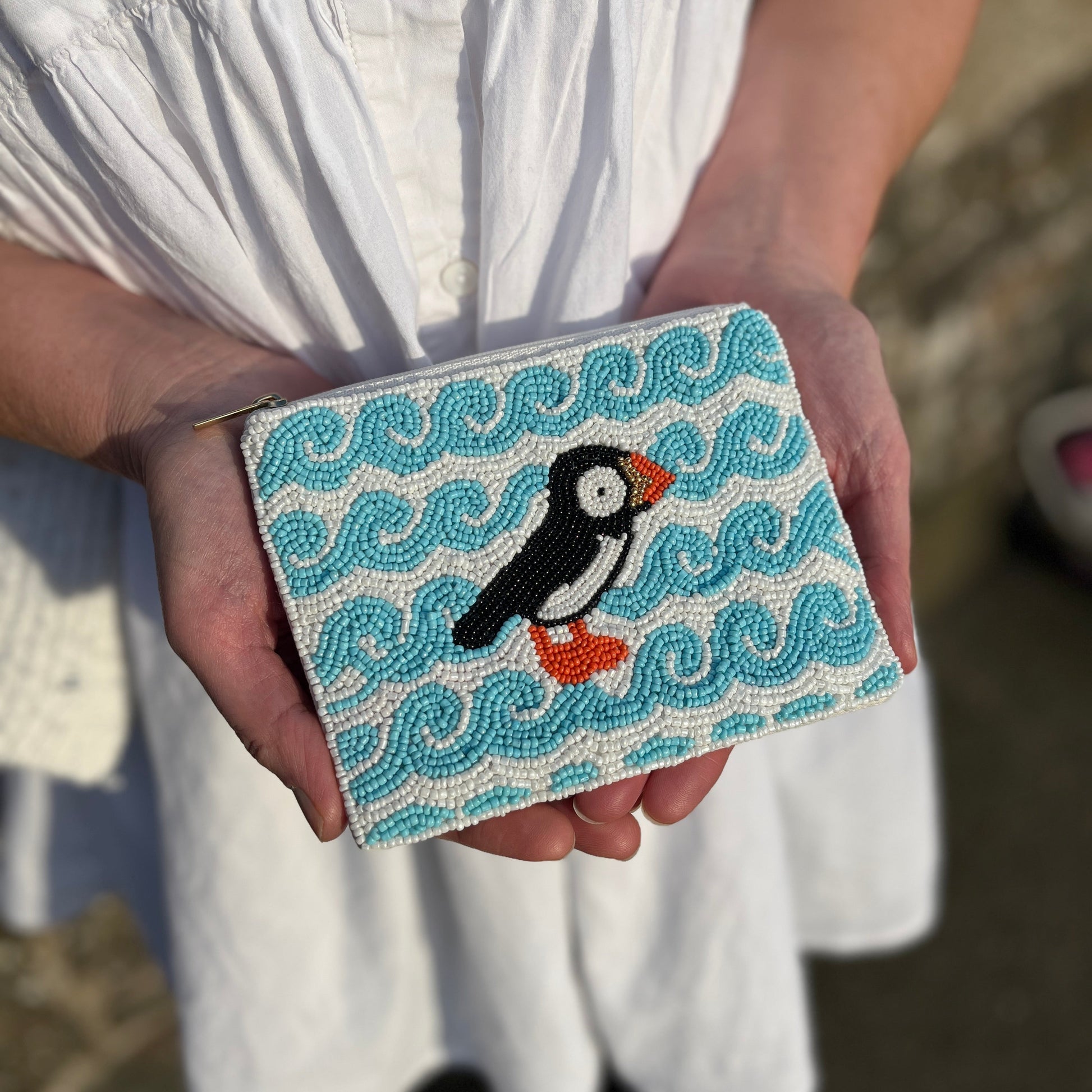 Puffin beaded purse held in hand showing size and beadwork