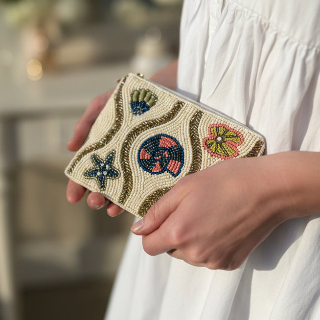 Shell beaded purse with seashell motifs held in hand showing size
