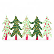 East End Press Christmas trees paper garland standing along a white mantelpiece beside a small potted tree