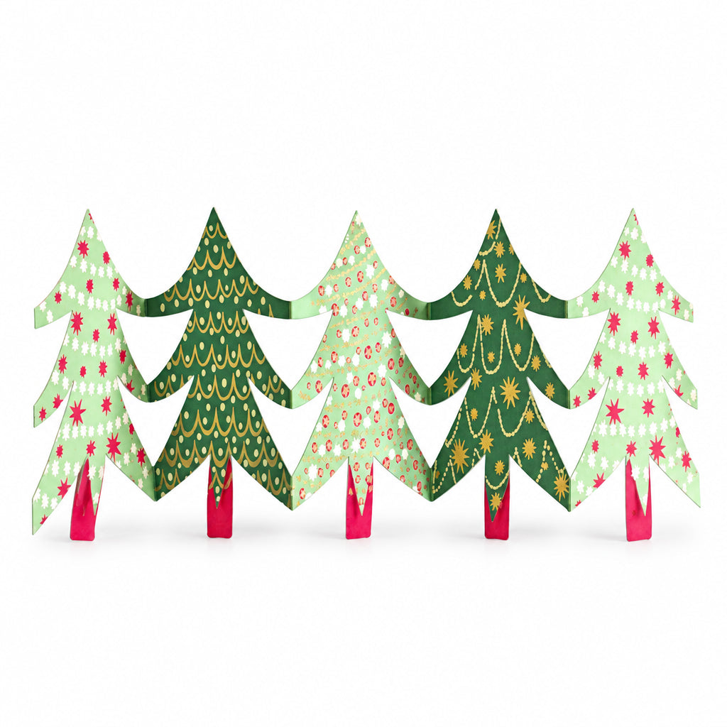 East End Press Christmas trees paper garland standing along a white mantelpiece beside a small potted tree