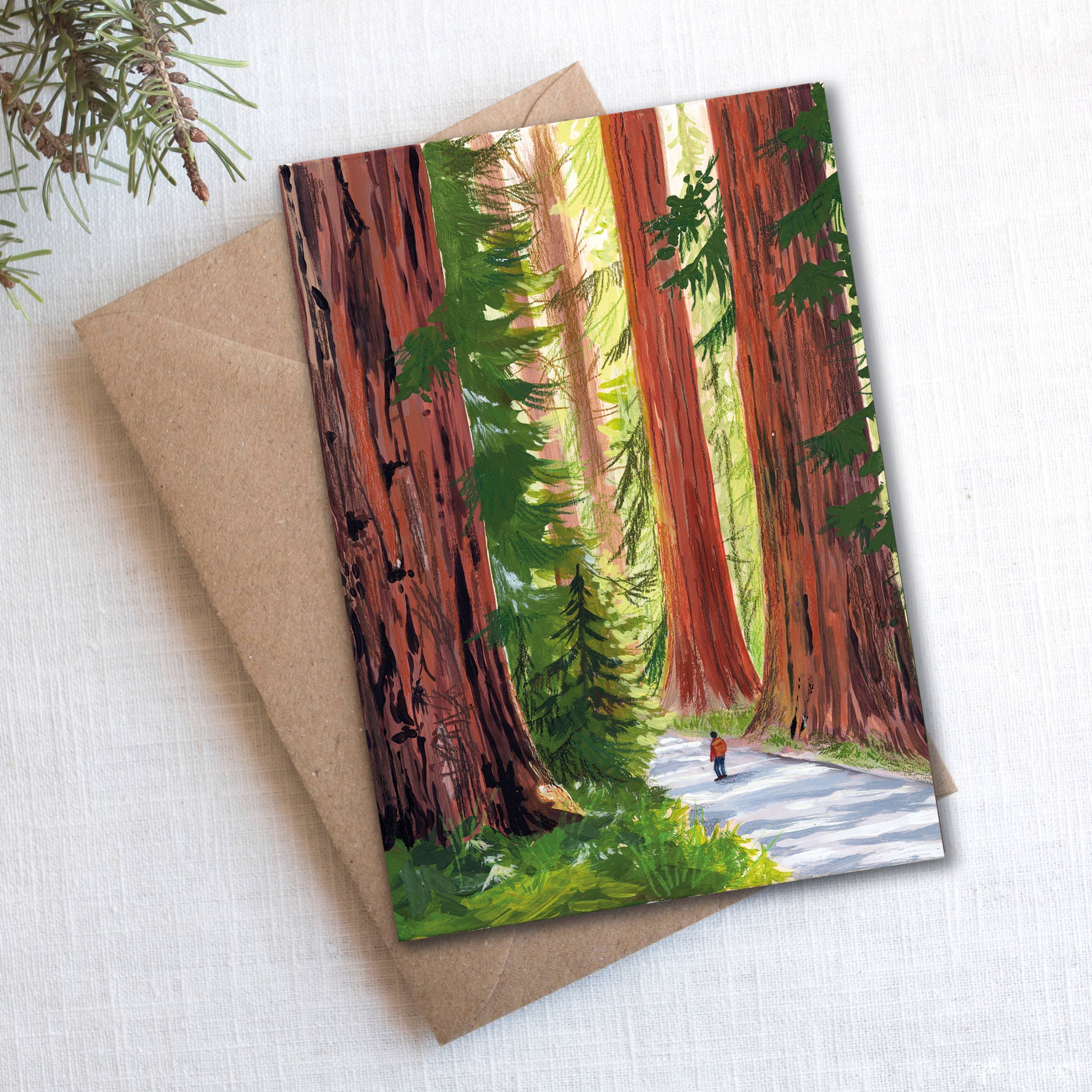 Giant Redwoods card styled with pine sprigs and kraft envelope on white linen background