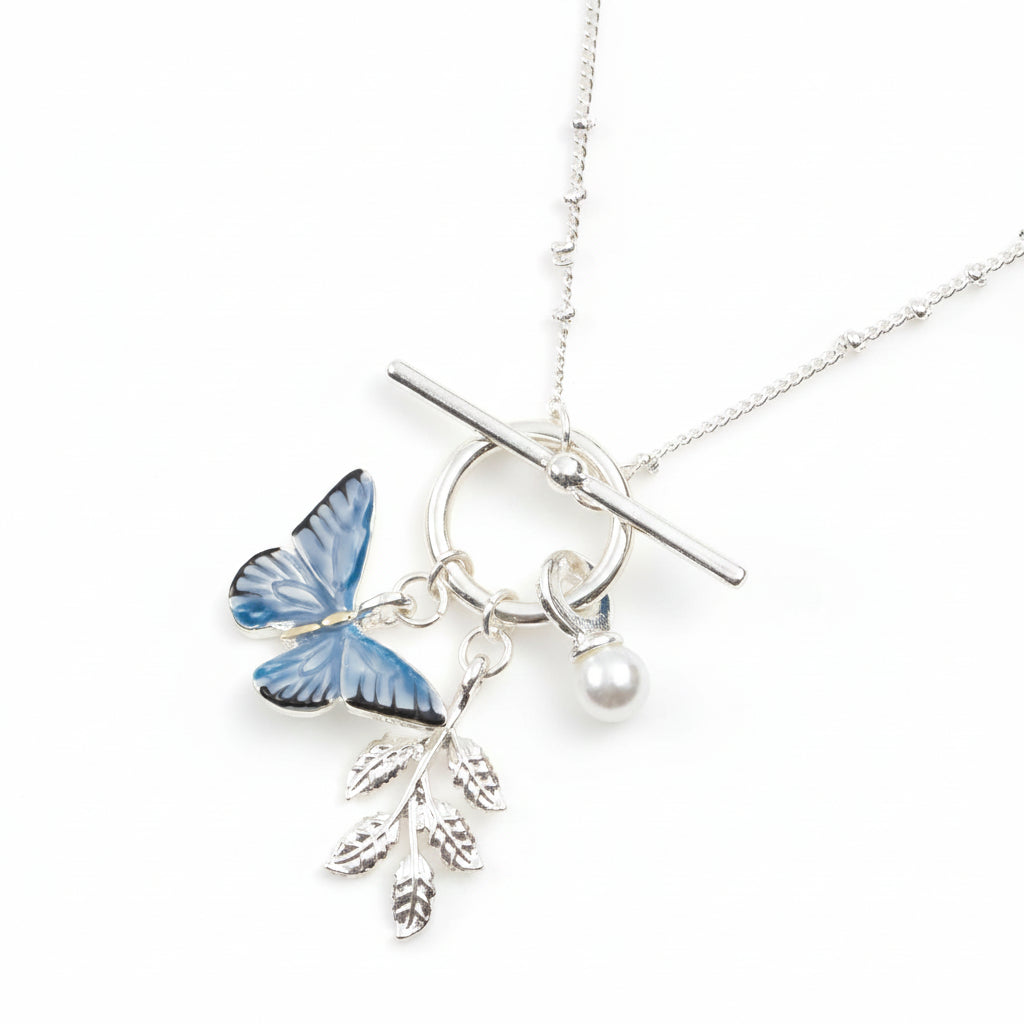 Blue butterfly T-bar necklace with pearl and leaf charms on white
