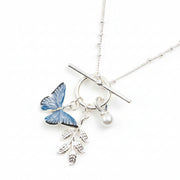 Blue butterfly T-bar necklace with pearl and leaf charms on white