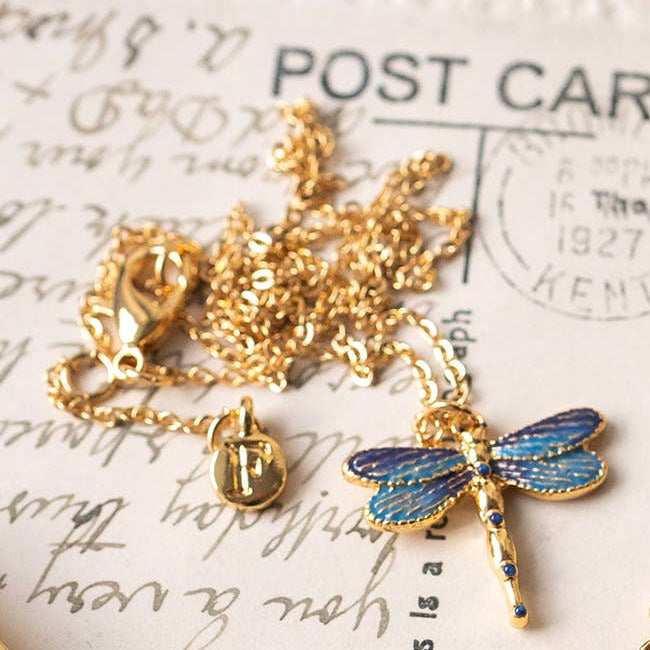 Dragonfly necklace and matching earrings styled on vintage postcards with brass bell