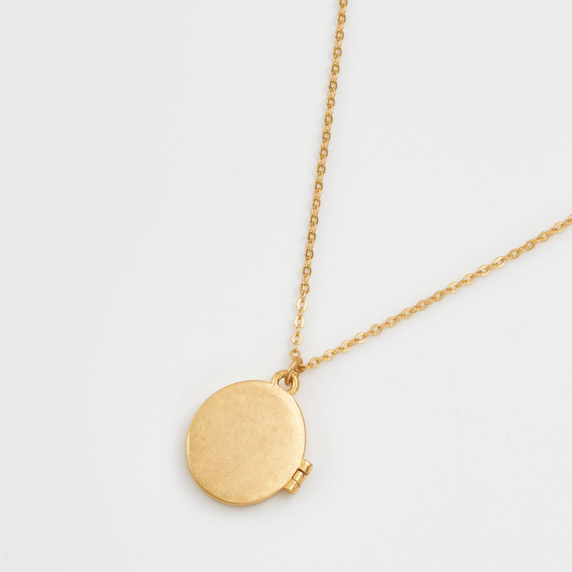 Gold locket necklace back view showing plain polished finish on white