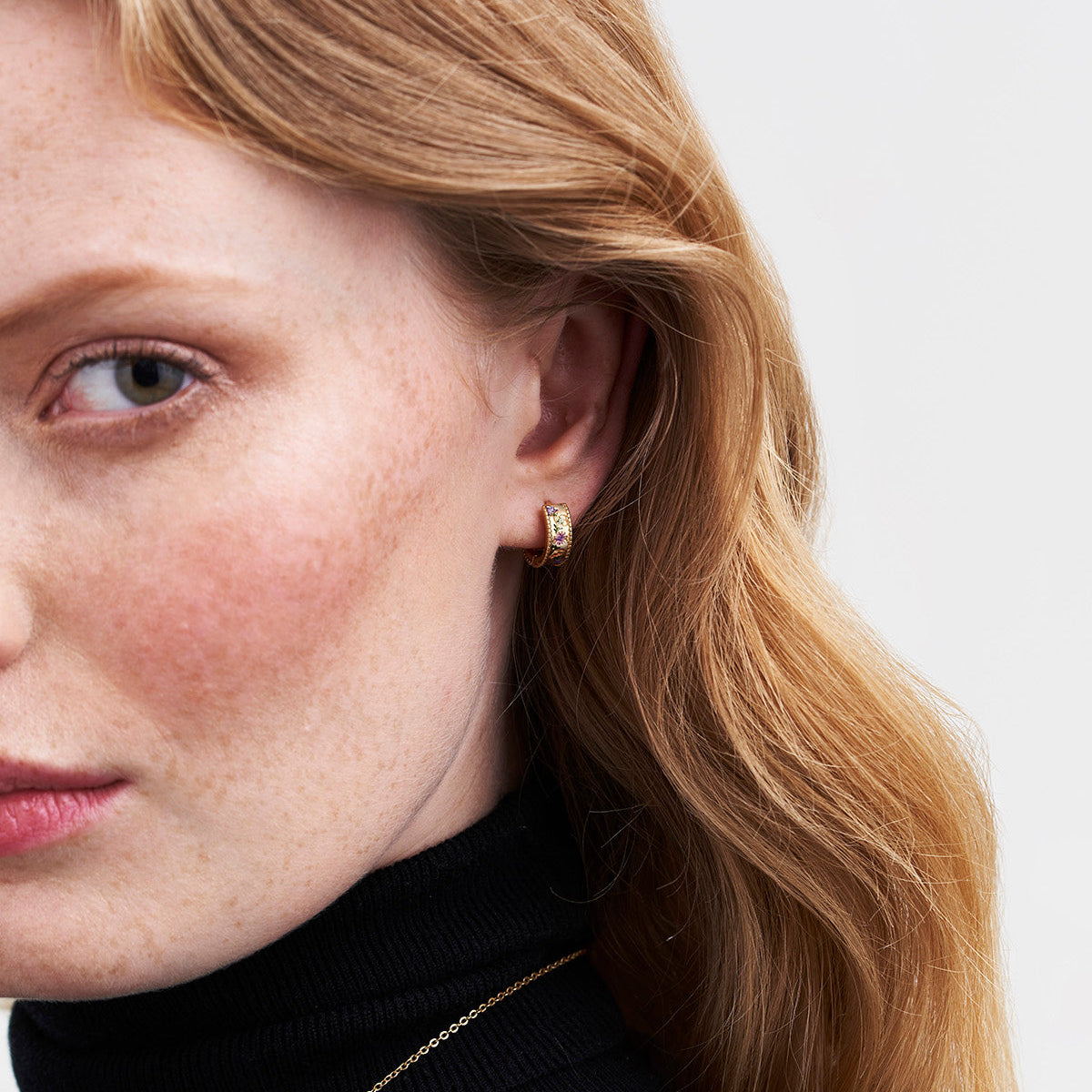 Model wearing the Folksy Floral Gold Huggie Earrings