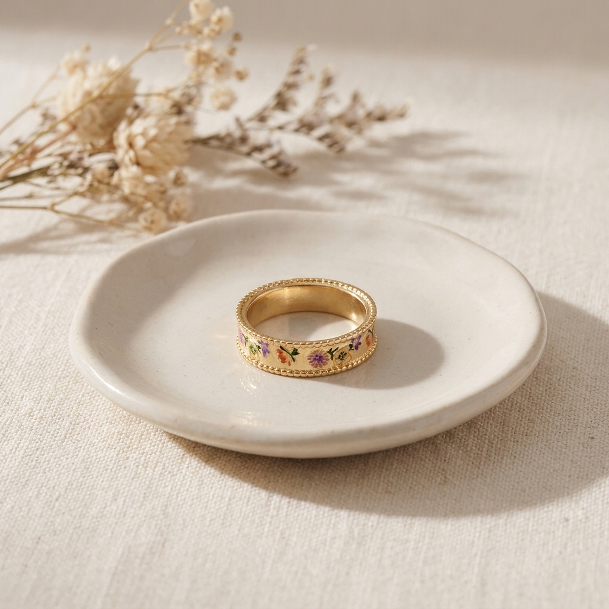 Folksy Floral Gold Ring styled on a ceramic dish with cream linen