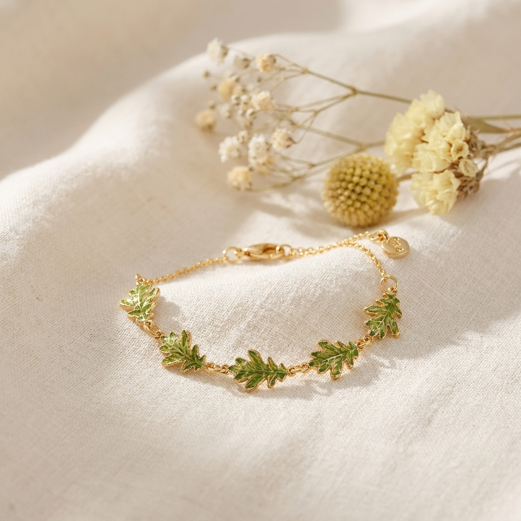 Oak Leaf Gold Bracelet styled on cream linen with dried flowers