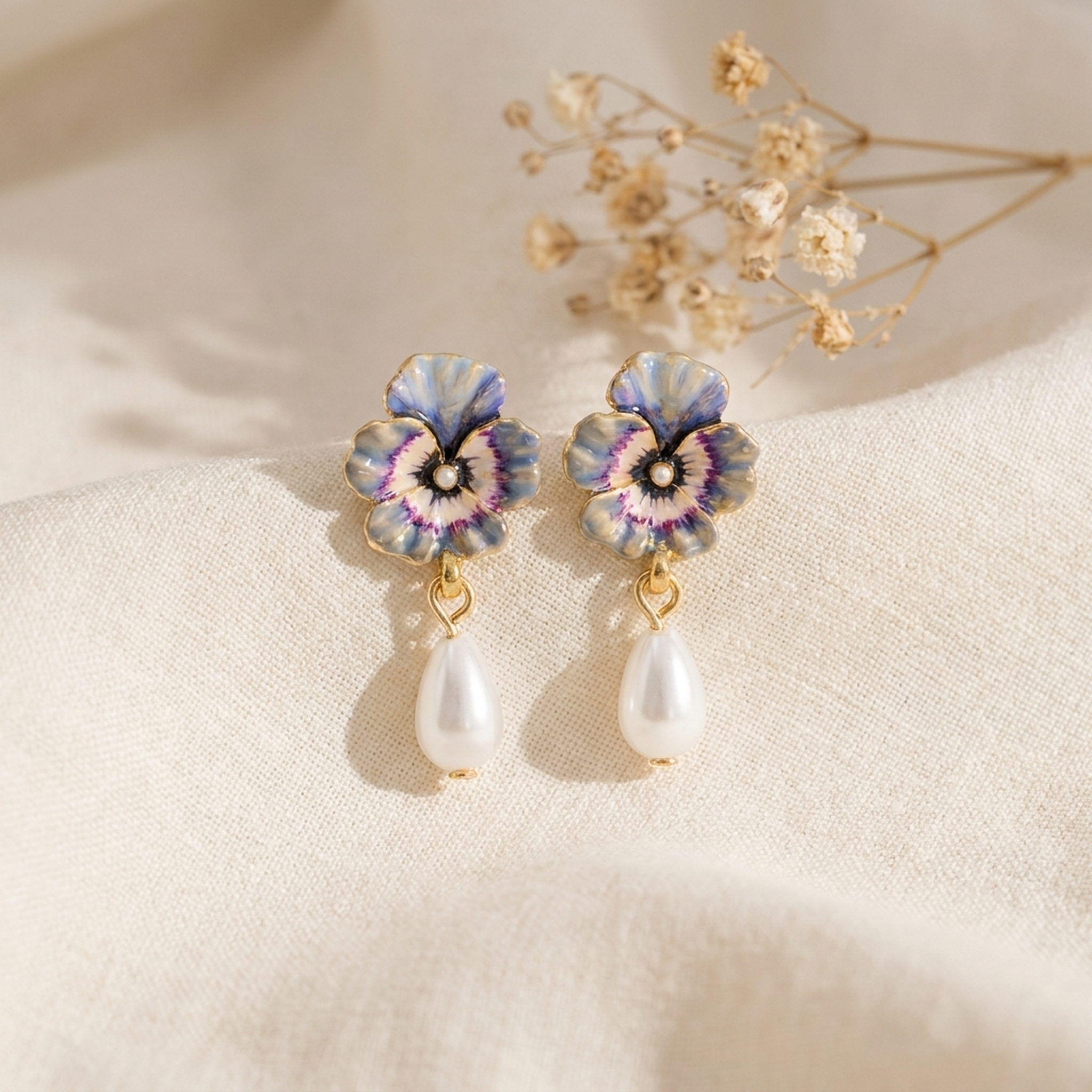 Pansy Pearl Drop Earrings styled on cream linen with dried flowers