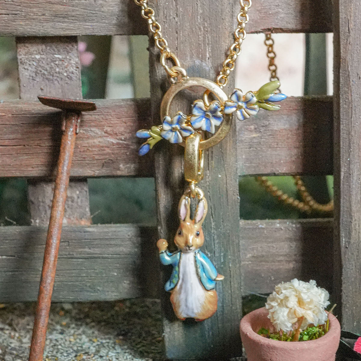 Peter Rabbit Forget-Me-Not Toggle Necklace styled with rustic wooden props