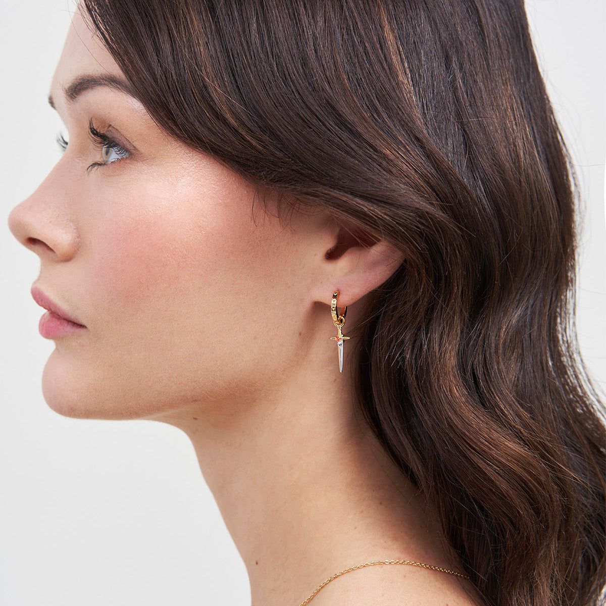Model wearing the Rose Dagger Huggie Earrings
