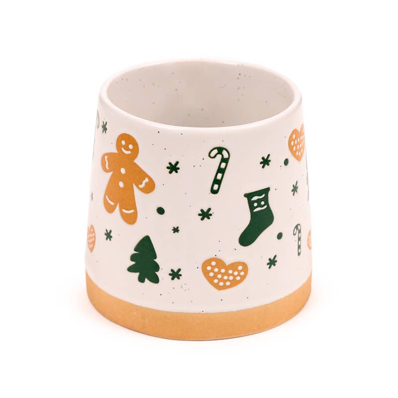 Festive Gingerbread Man Tapered Stoneware Mug featuring candy canes, stockings, and trees around the surface.