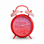 Red twin-bell alarm clock with pink dial shown beside its gift box