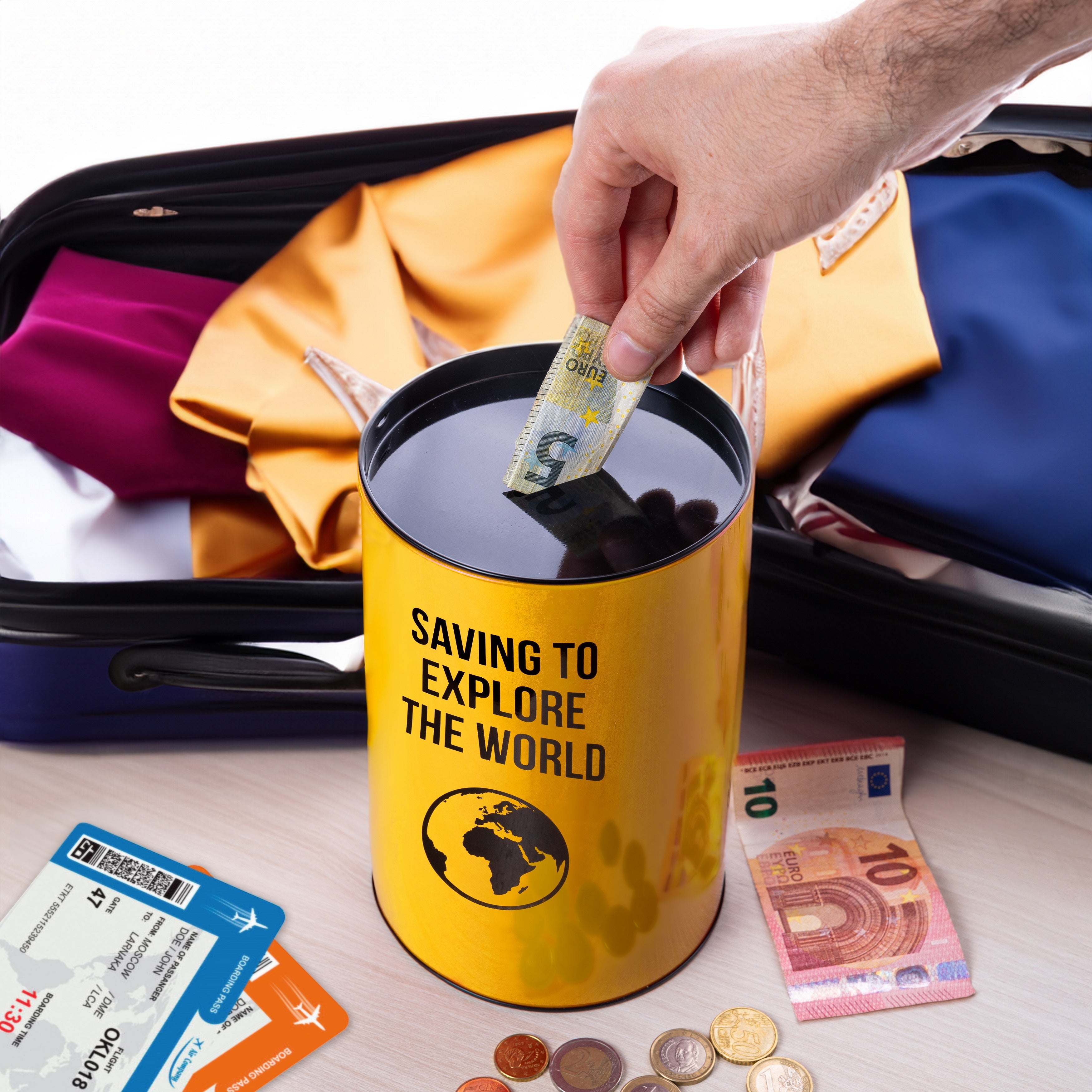 Yellow money tin packed in an open suitcase with cards and currency