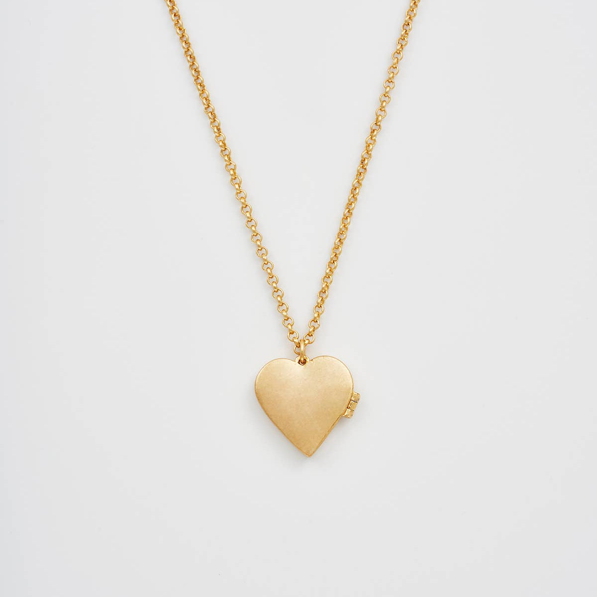 Back view of floral heart gold locket necklace pendant on white background.