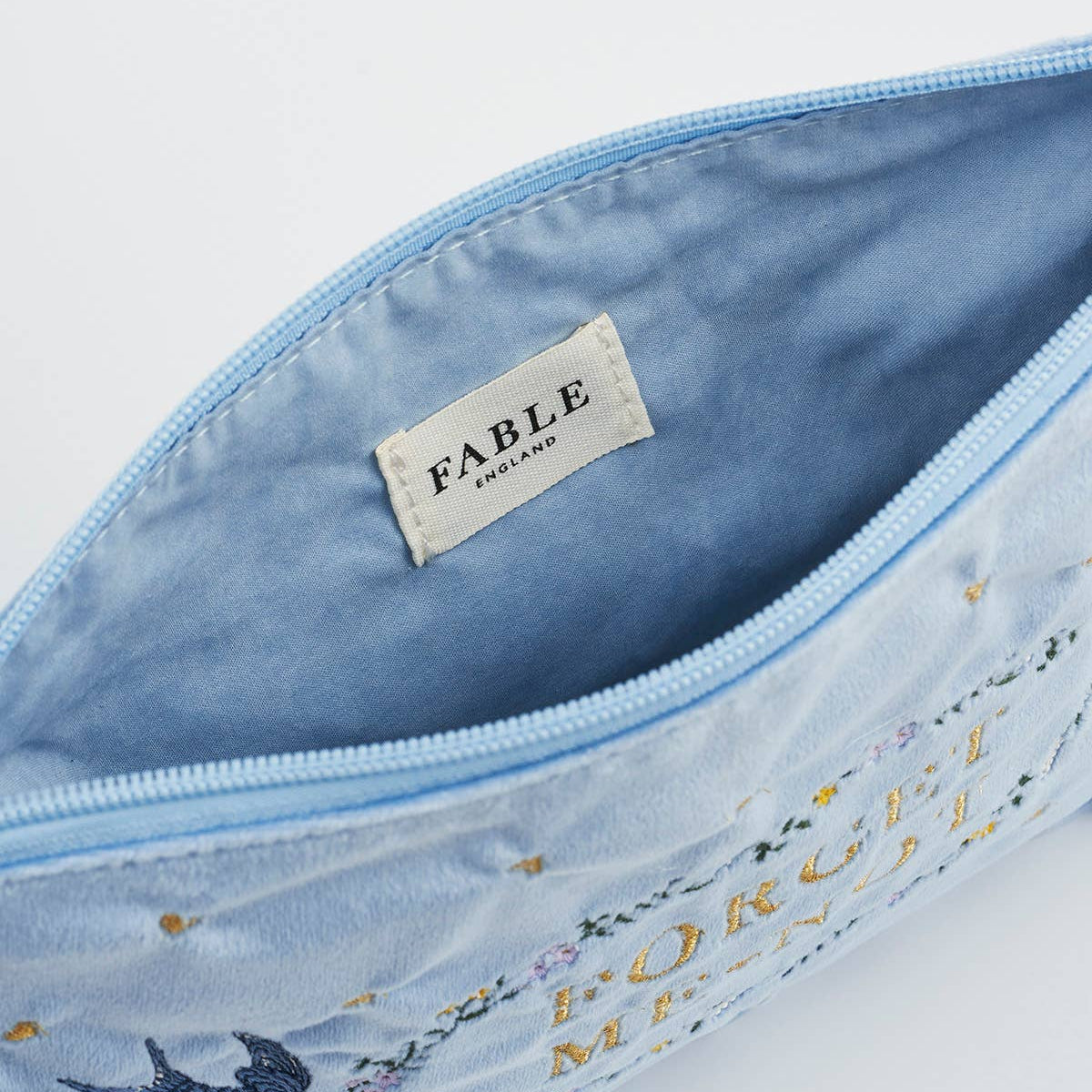 Interior view of blue velvet pouch with fabric label
