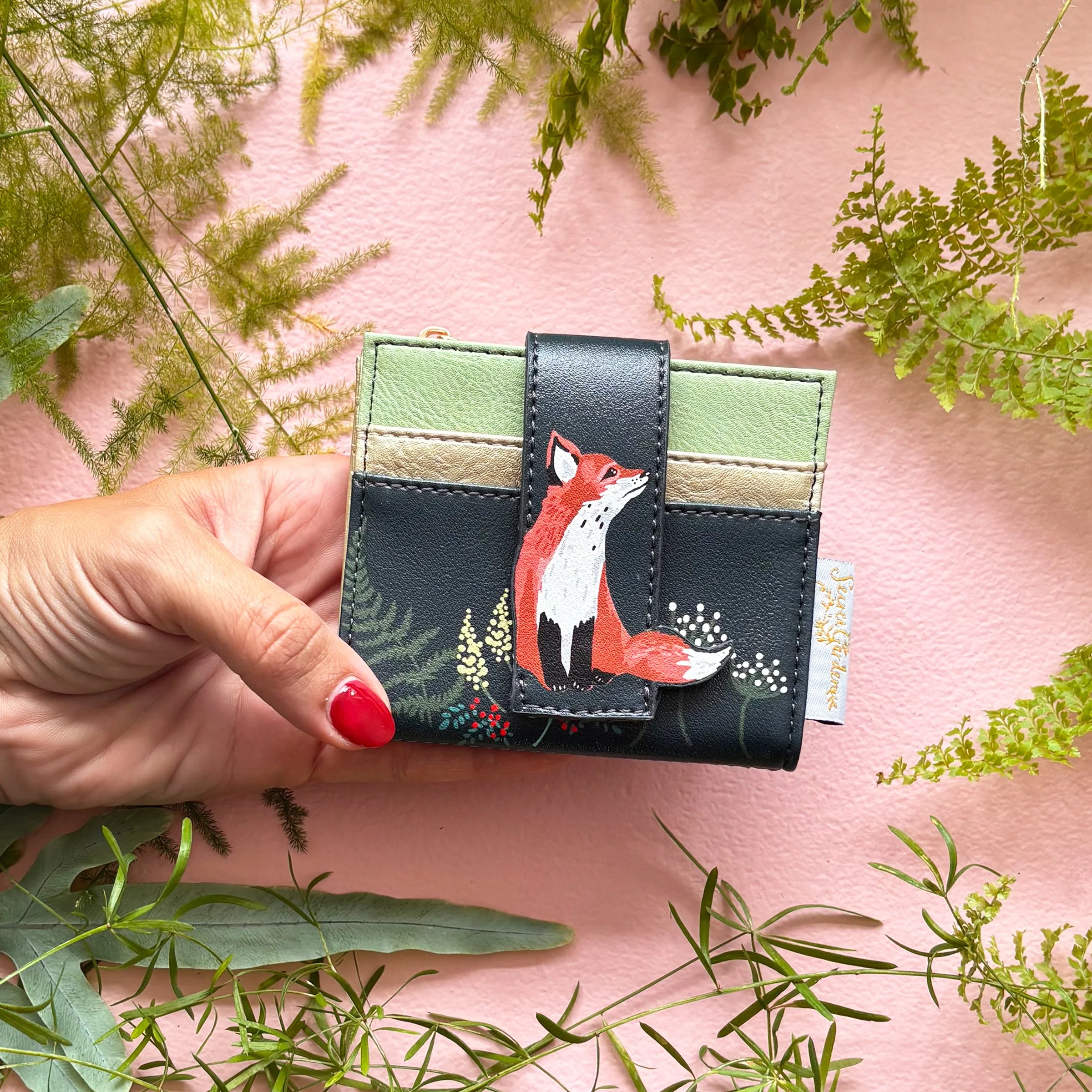 Fox cardholder held in hand showing compact size and front design