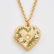Close-up of Gaia Lily Heart Locket Necklace with hand-painted enamel lilies and faux pearl detail.