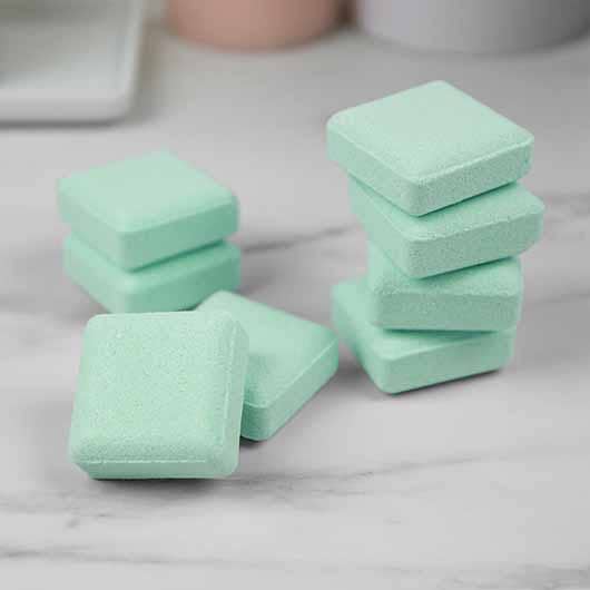 Mint green Hangover Cure shower steamer cubes piled on a marble surface