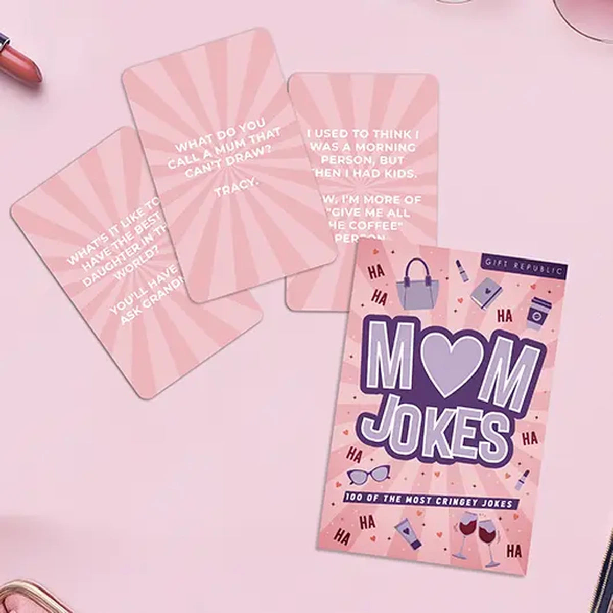 Mum Jokes cards fanned out on a soft pink background