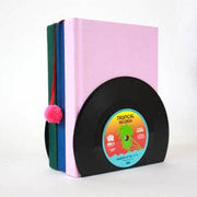 Vinyl record bookend holding colourful books with pompom bookmark on white