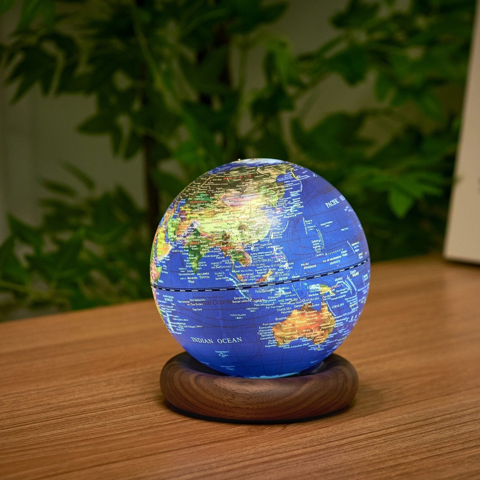 Dark blue AtlasGlobe light turned to show Asia and Australia, glowing