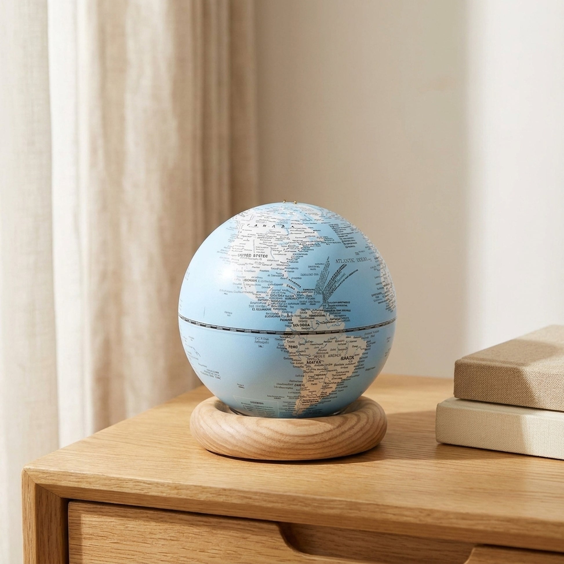 Sky blue AtlasGlobe light on an oak side table beside a stack of books