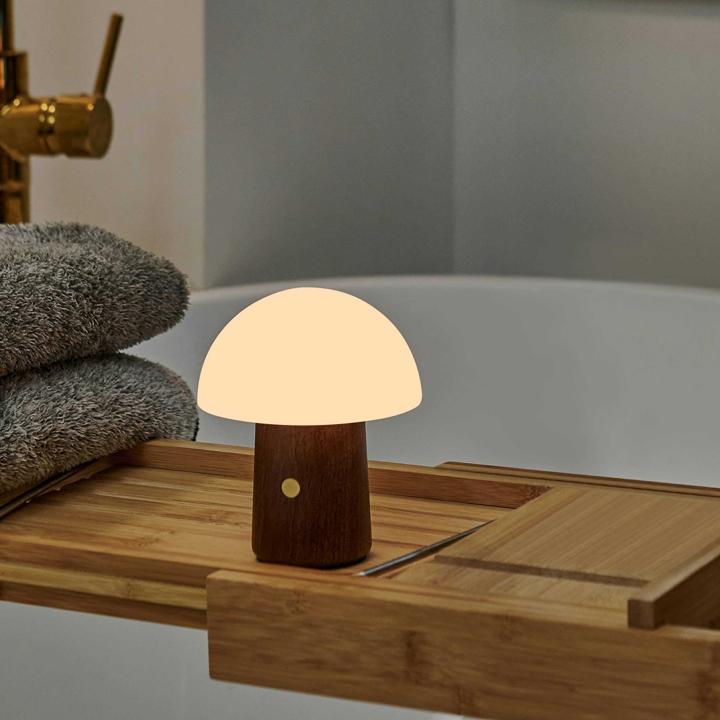 Mini Alice Mushroom Lamp glowing softly on a bamboo bath caddy