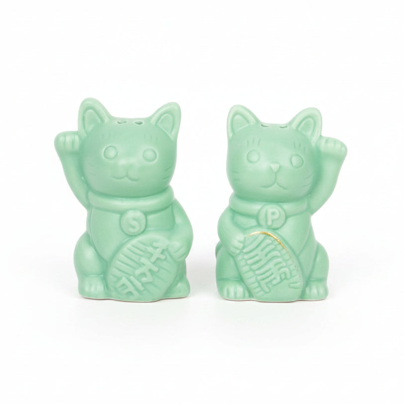 Two green ceramic lucky cat salt and pepper shakers, white background