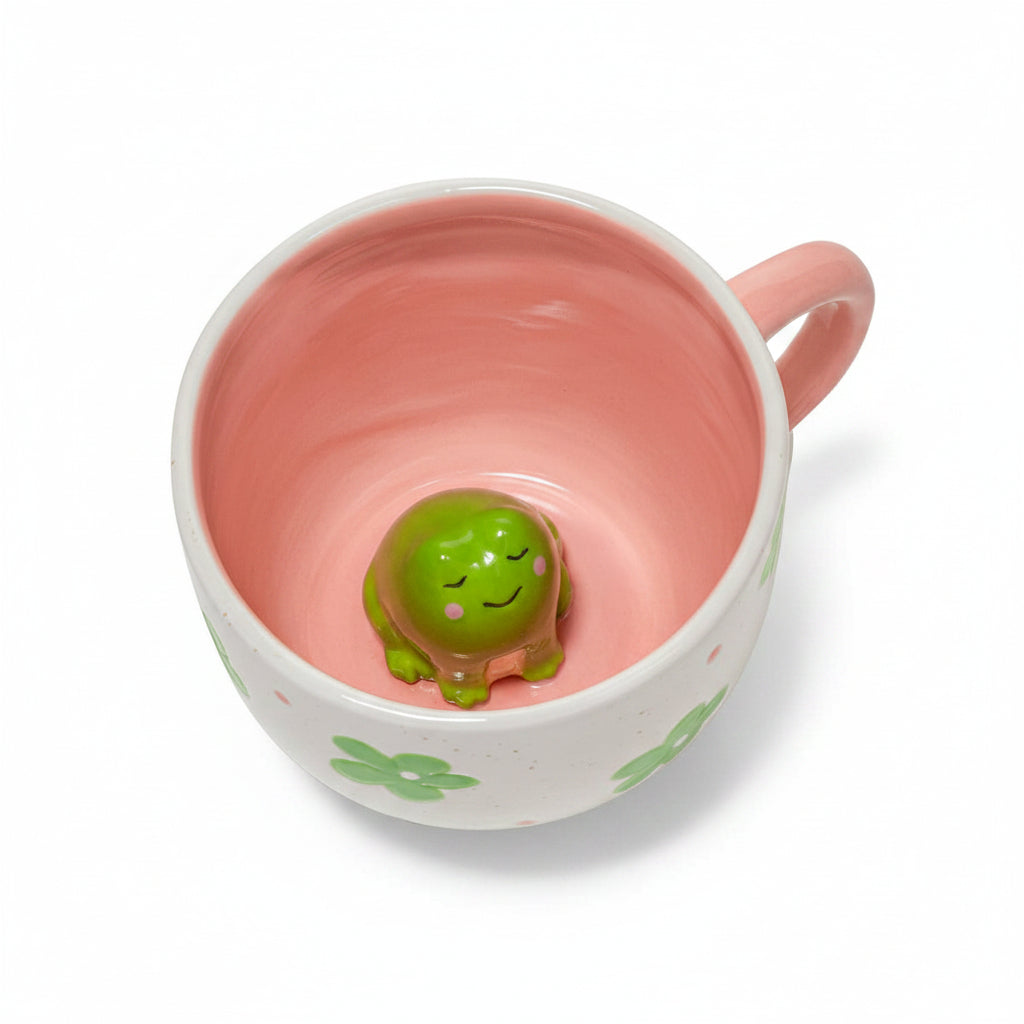 Top view of hidden frog mug showing cute 3D green frog inside pink interior