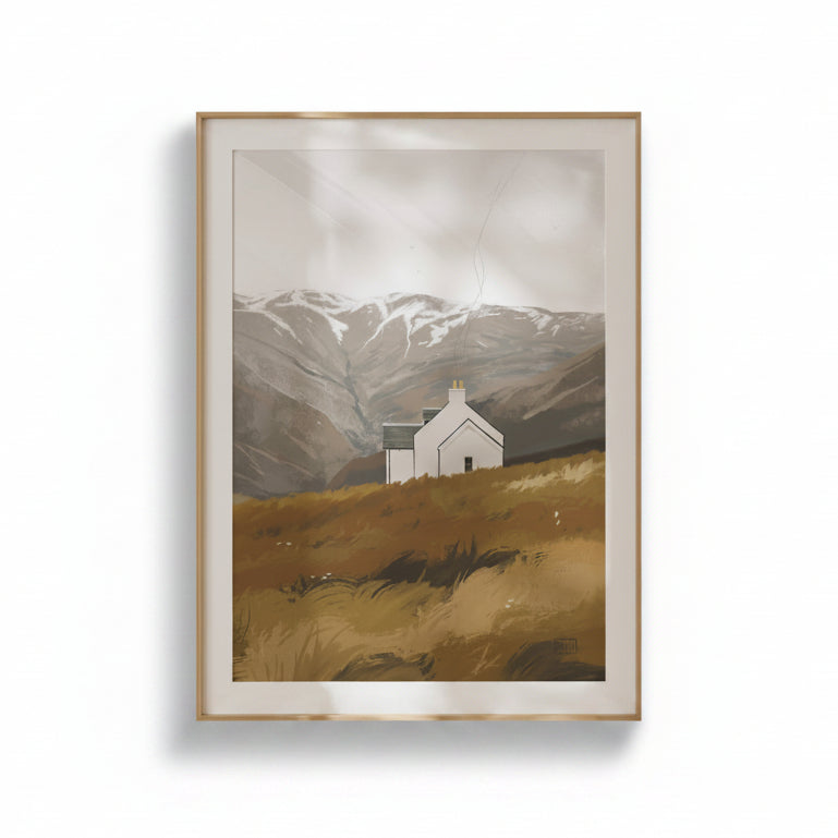 A framed art print depicting a small white church on a golden-brown hillside with snow-capped mountains in the background, set against a clean white wall.