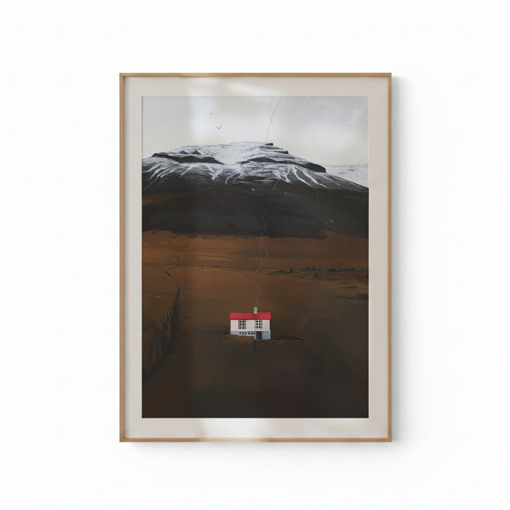 Framed artwork of a house in a landscape with mountains on a beige wall.