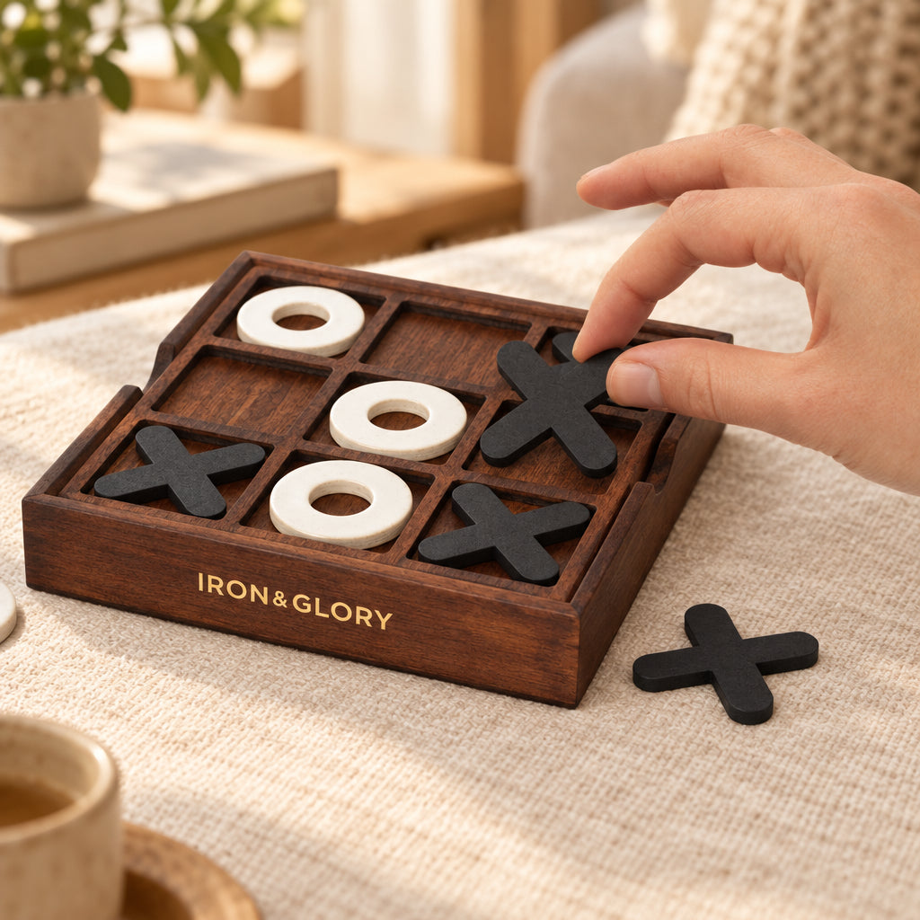 Hand placing a black cross on the Iron & Glory wooden noughts and crosses board