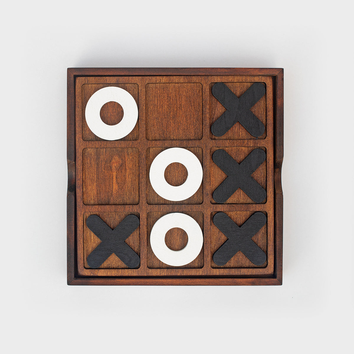 Iron & Glory wooden noughts and crosses board, top down, grey background