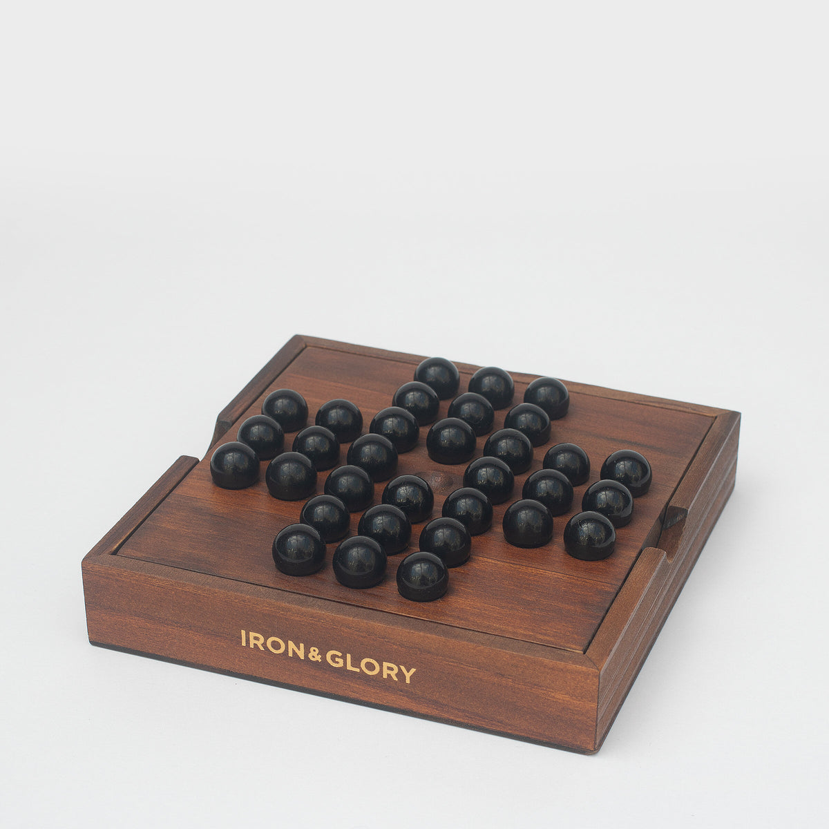 Iron & Glory wooden solitaire game at an angle showing the gold logo
