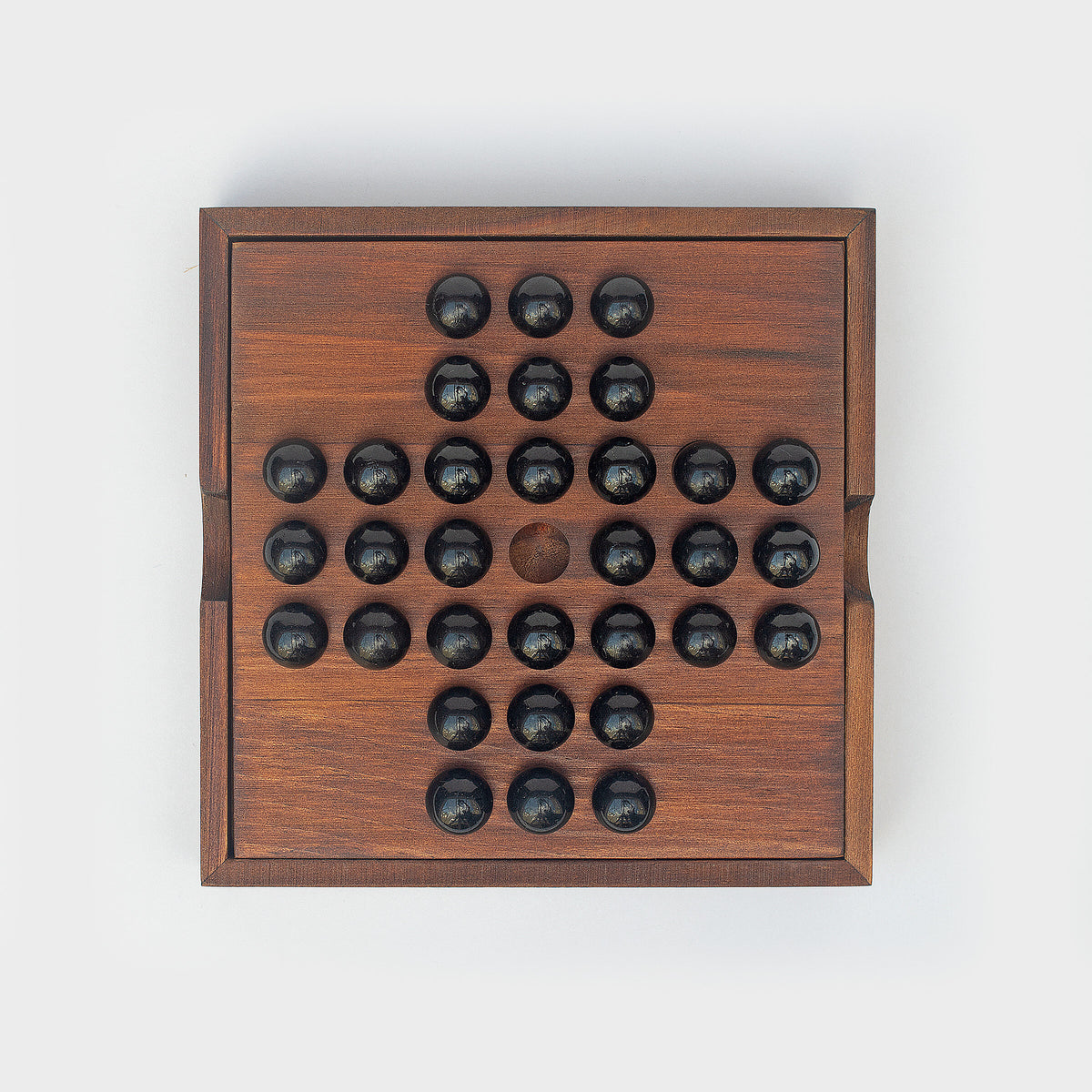 Iron & Glory wooden solitaire board, top down with black glass marbles