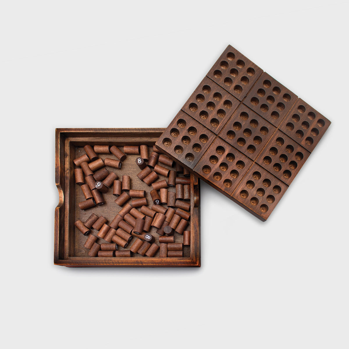 Wooden sudoku box open with the board lifted and pegs stored inside