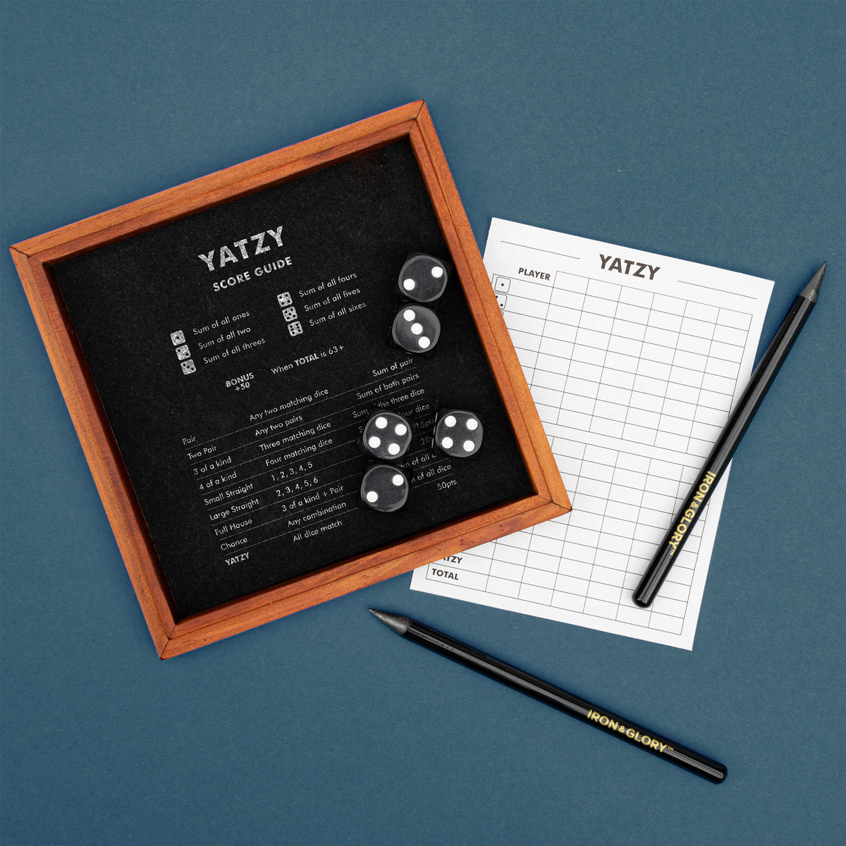 Yatzy wooden dice tray and score sheet on a slate blue background