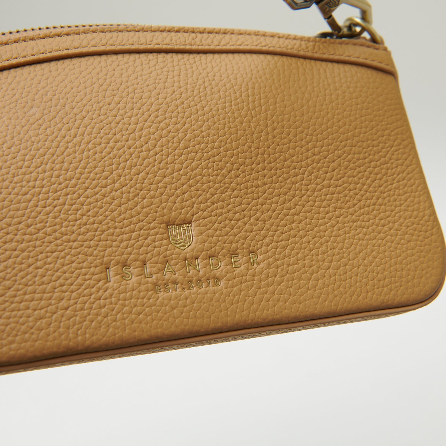Close-up of embossed Islander branding on tan leather back panel