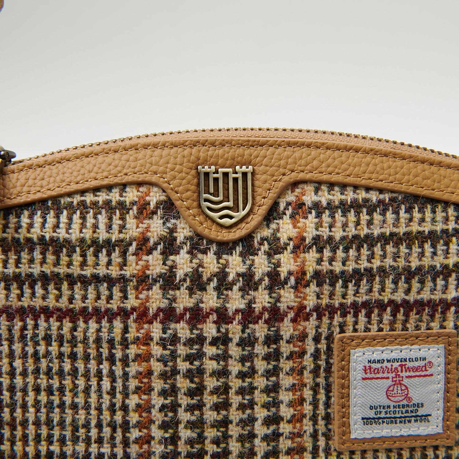Close-up of Islander clasp and Harris Tweed label on beige dogtooth purse