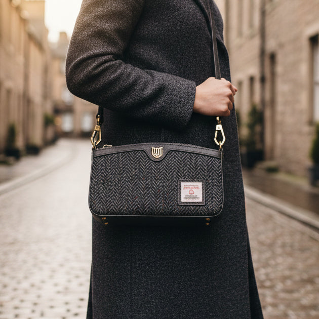 Ailsa black grey herringbone Harris Tweed purse held on Scottish street