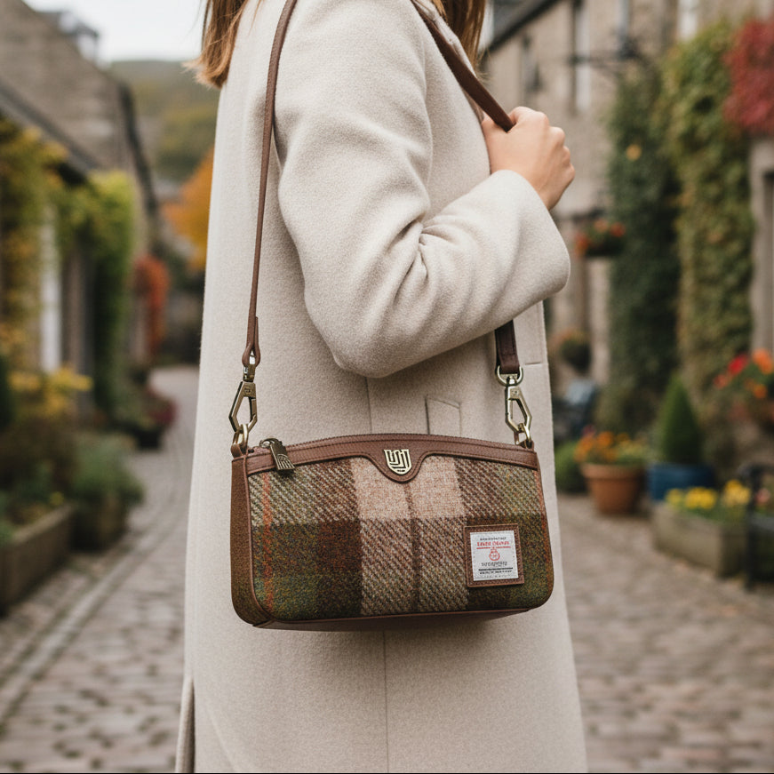 Ailsa chestnut tartan Harris Tweed purse worn as crossbody on village street