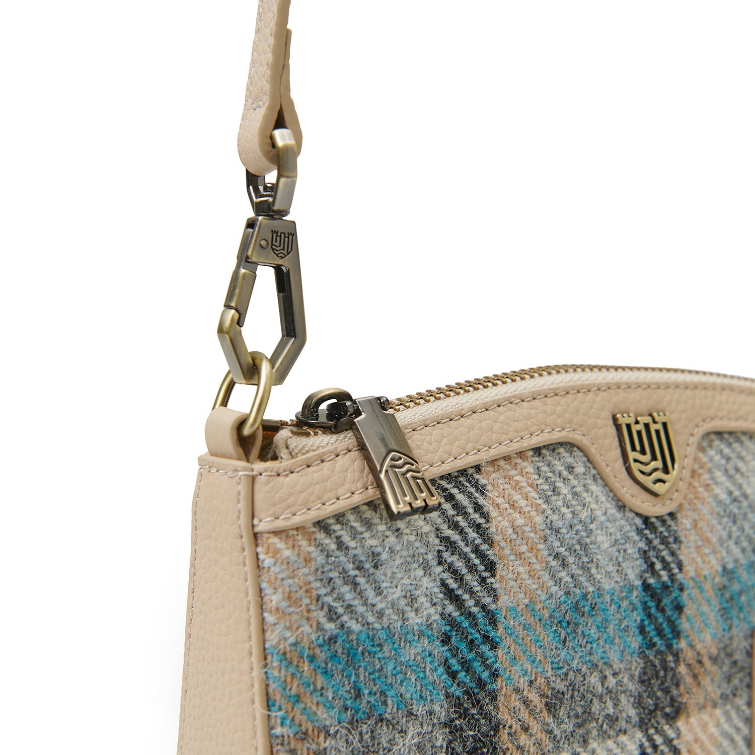 Close-up of tan leather strap clip and brass hardware on Islander purse