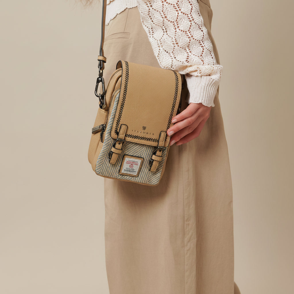 Baby Jura crossbody in stone leather and cream herringbone tweed worn across the body