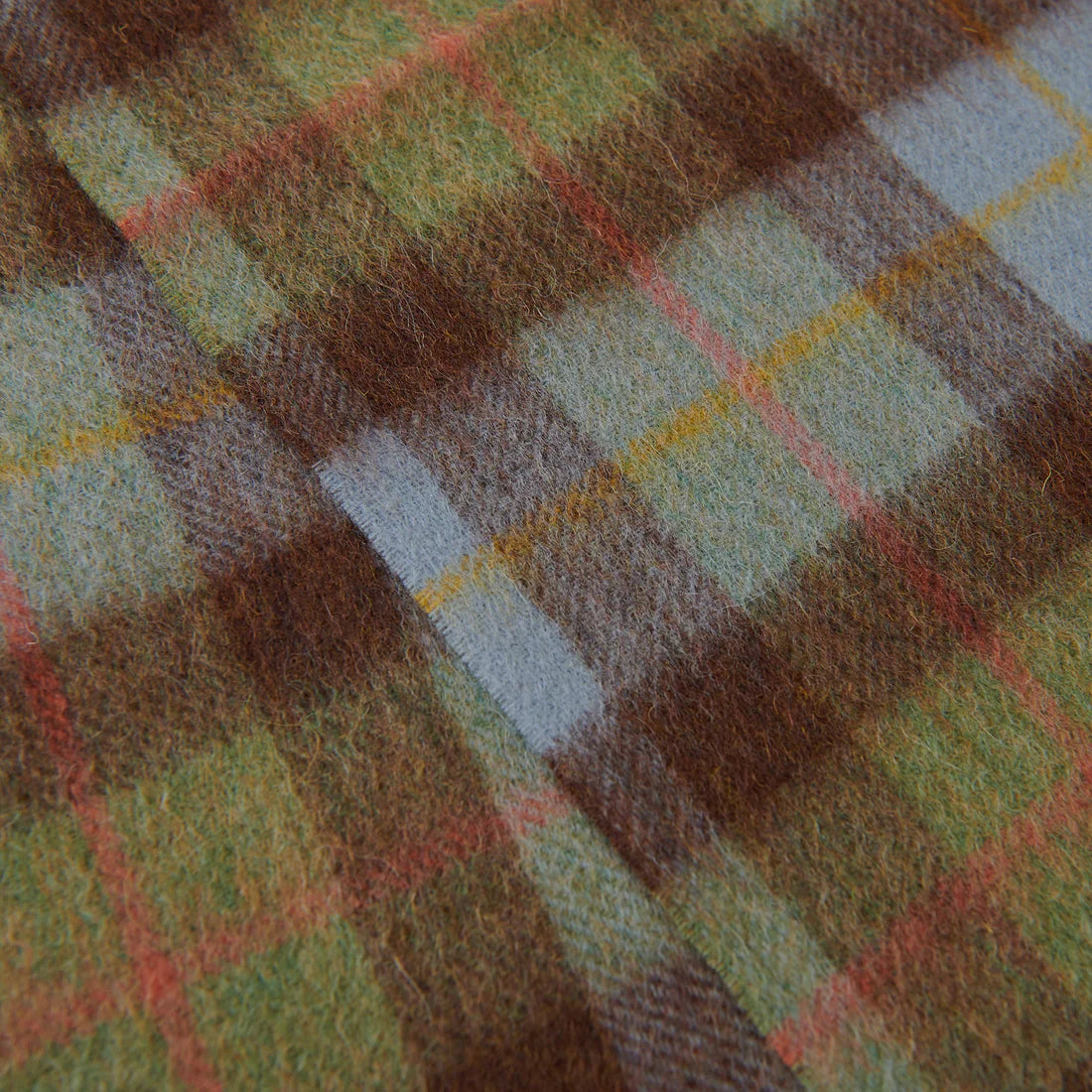 Detailed texture of chestnut and blue tartan lambswool fabric pattern.