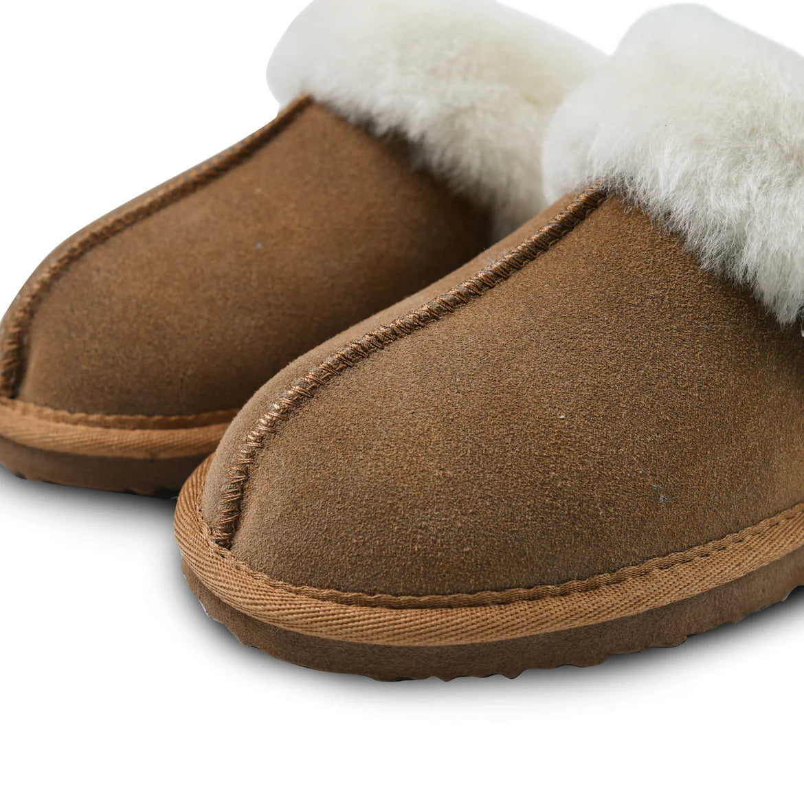 Close-up of chestnut suede sheepskin slippers showing stitching and soft white lining