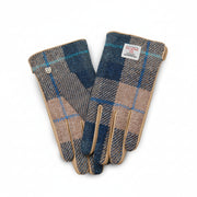 Navy beige tartan Harris Tweed gloves holding steaming mug on wooden fence outdoors